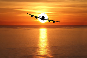 Beautiful sunset with airplane over the sea