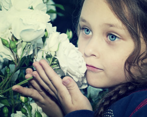 child smelling flowers